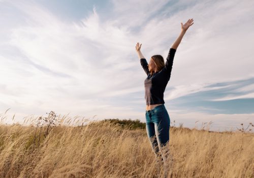 young-happy-woman-golden-field-sunset